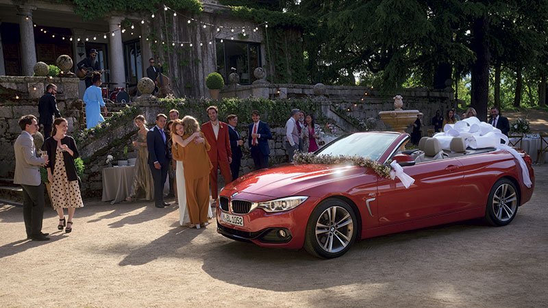 Vediamo una BMW rossa al ricevimento di un matrimonio